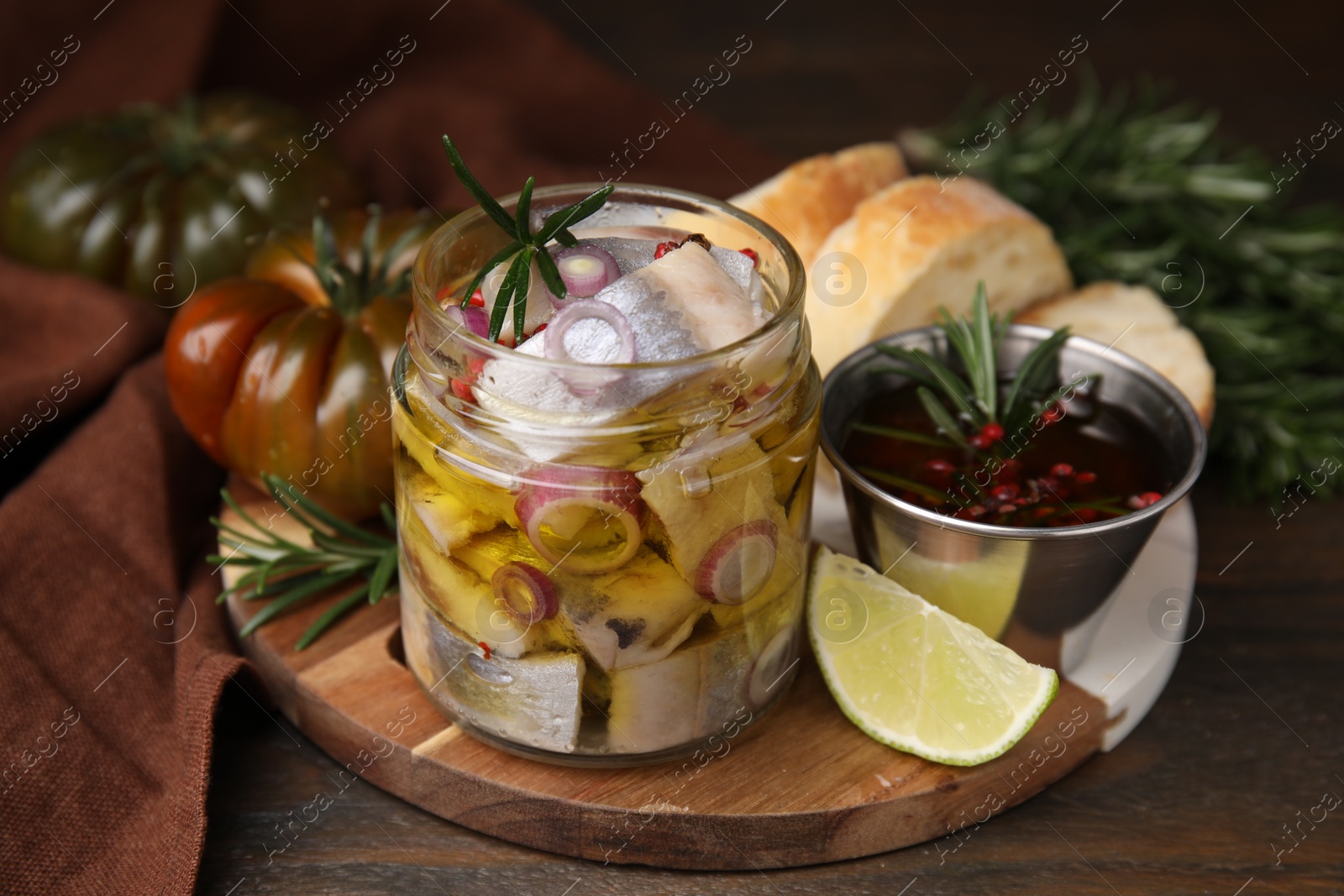 Photo of Tasty fish, onion, rosemary and marinade on wooden table, closeup