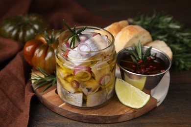 Tasty fish, onion, rosemary and marinade on wooden table, closeup