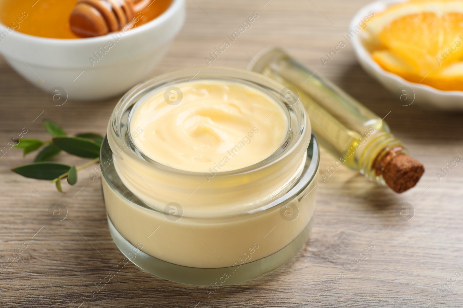 Photo of Body cream and cosmetic product on wooden table, closeup