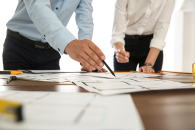 Photo of People working with construction drawings at table, closeup