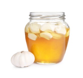 Photo of Honey with garlic in glass jar isolated on white