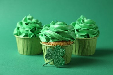 Photo of St. Patrick's day party. Tasty cupcakes on green background, closeup