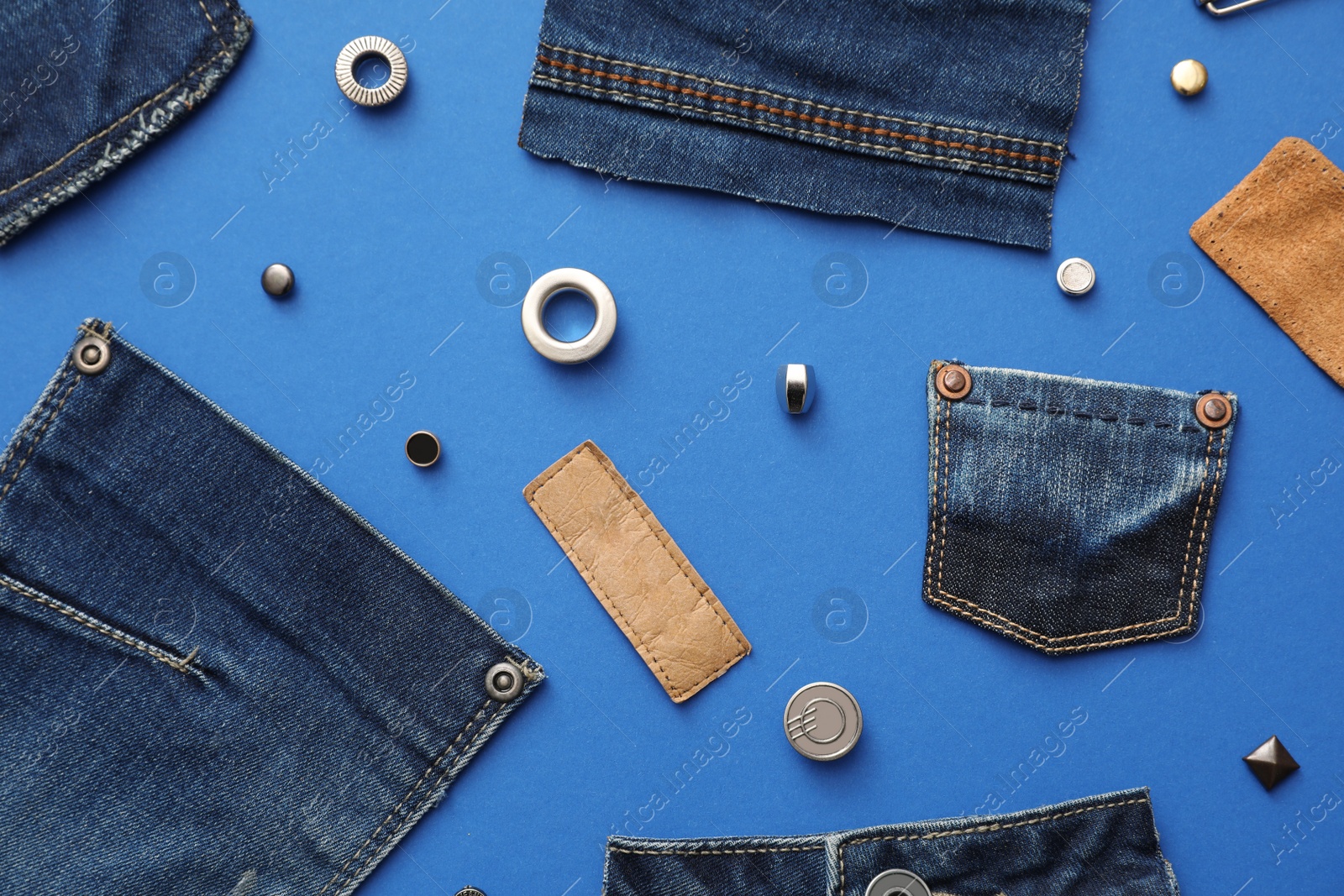 Photo of Flat lay composition with garment accessories and cutting details for jeans on blue background