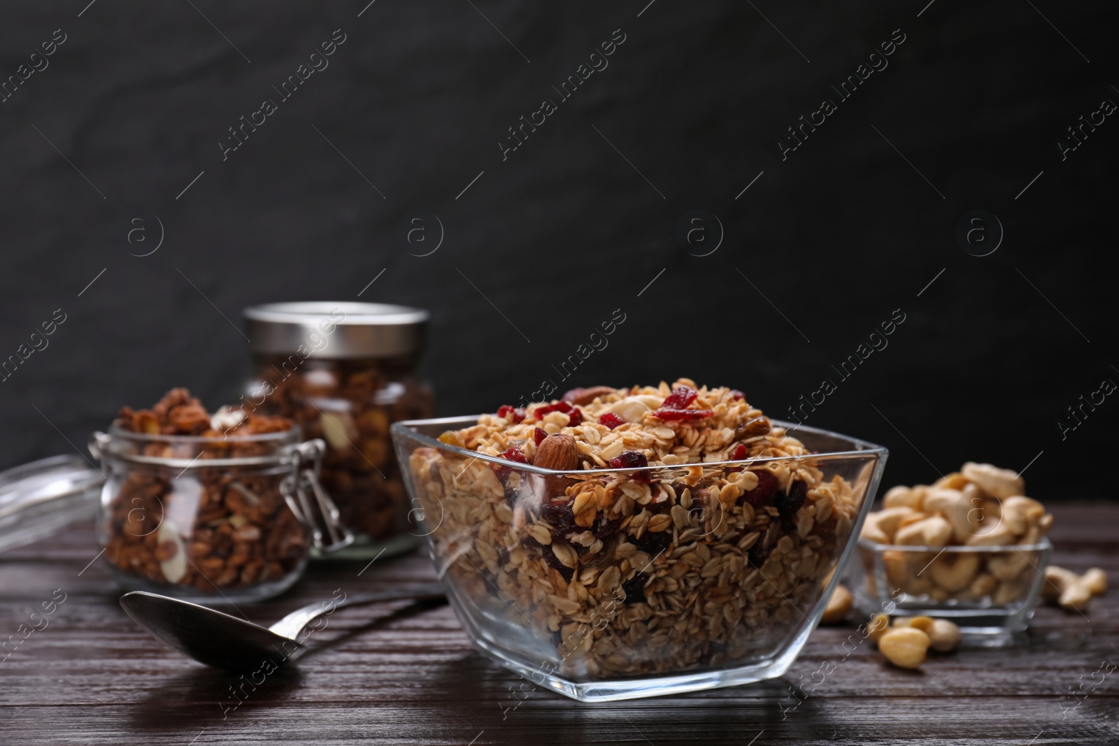 Photo of Tasty granola served with nuts and dry fruits on wooden table