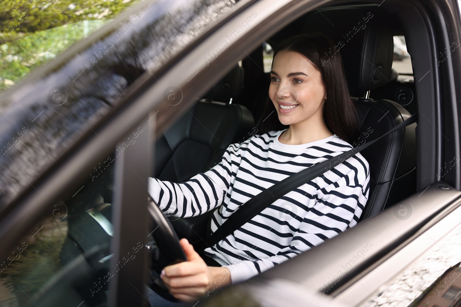 Photo of Woman with safety seat belt driving her modern car