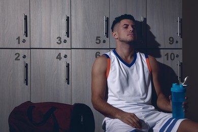 Image of Handsome tired man with shaker in locker room