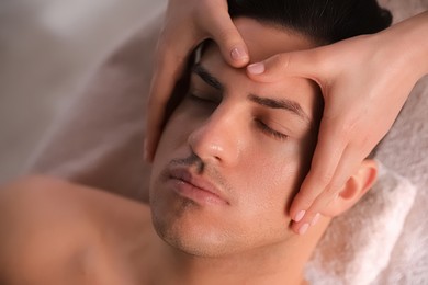 Photo of Man receiving facial massage in beauty salon, above view