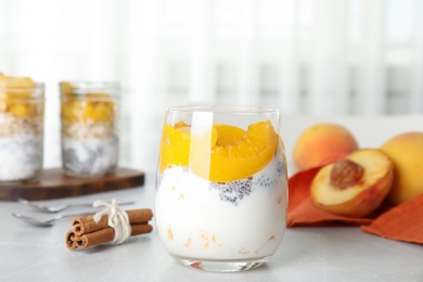 Photo of Tasty peach dessert with yogurt and chia seeds on light table