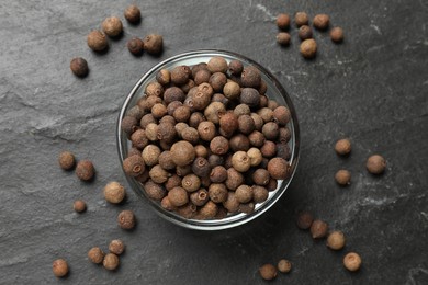Dry allspice berries (Jamaica pepper) on black table, top view