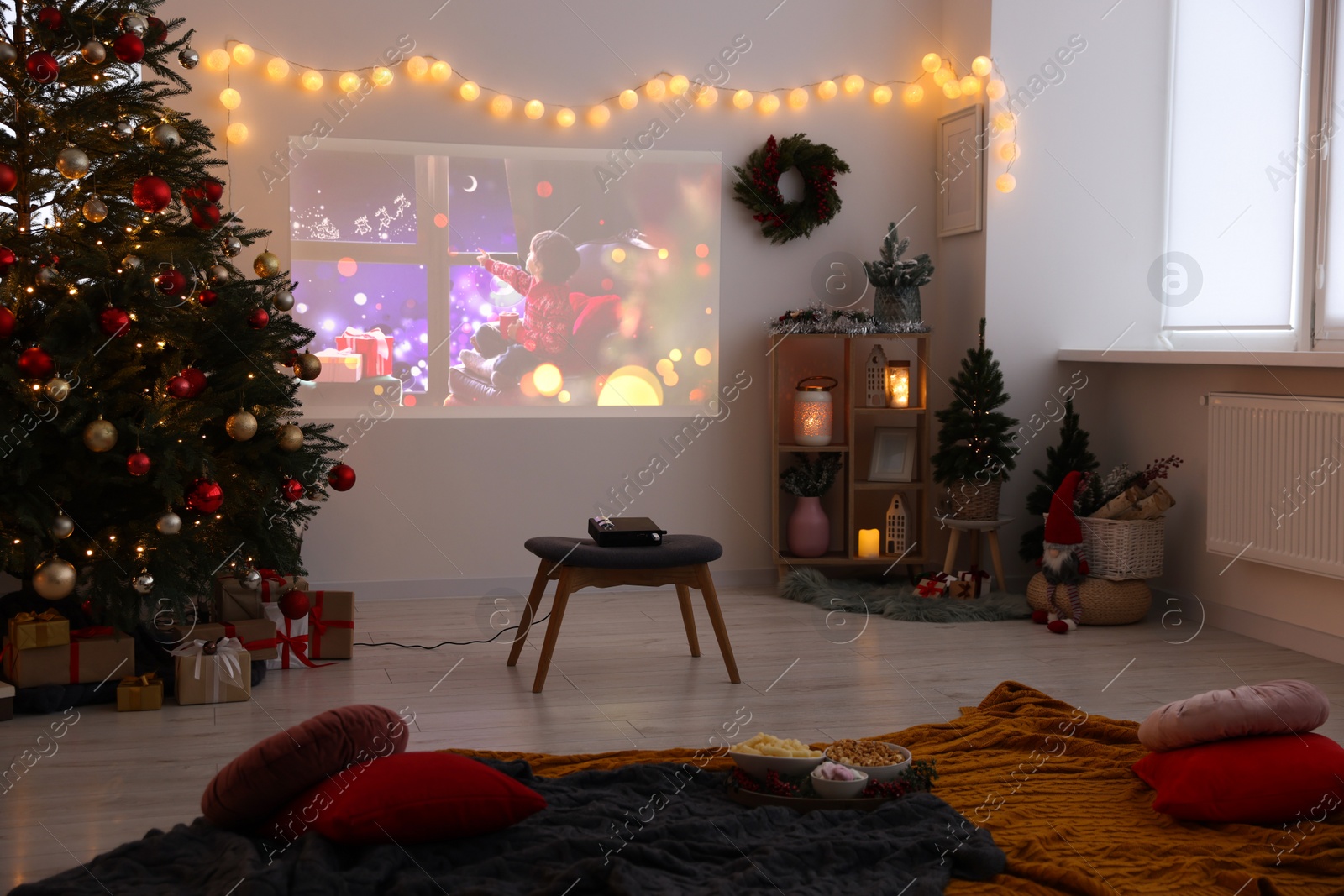 Photo of Video projector, Christmas tree, snacks, gifts and decorations in room