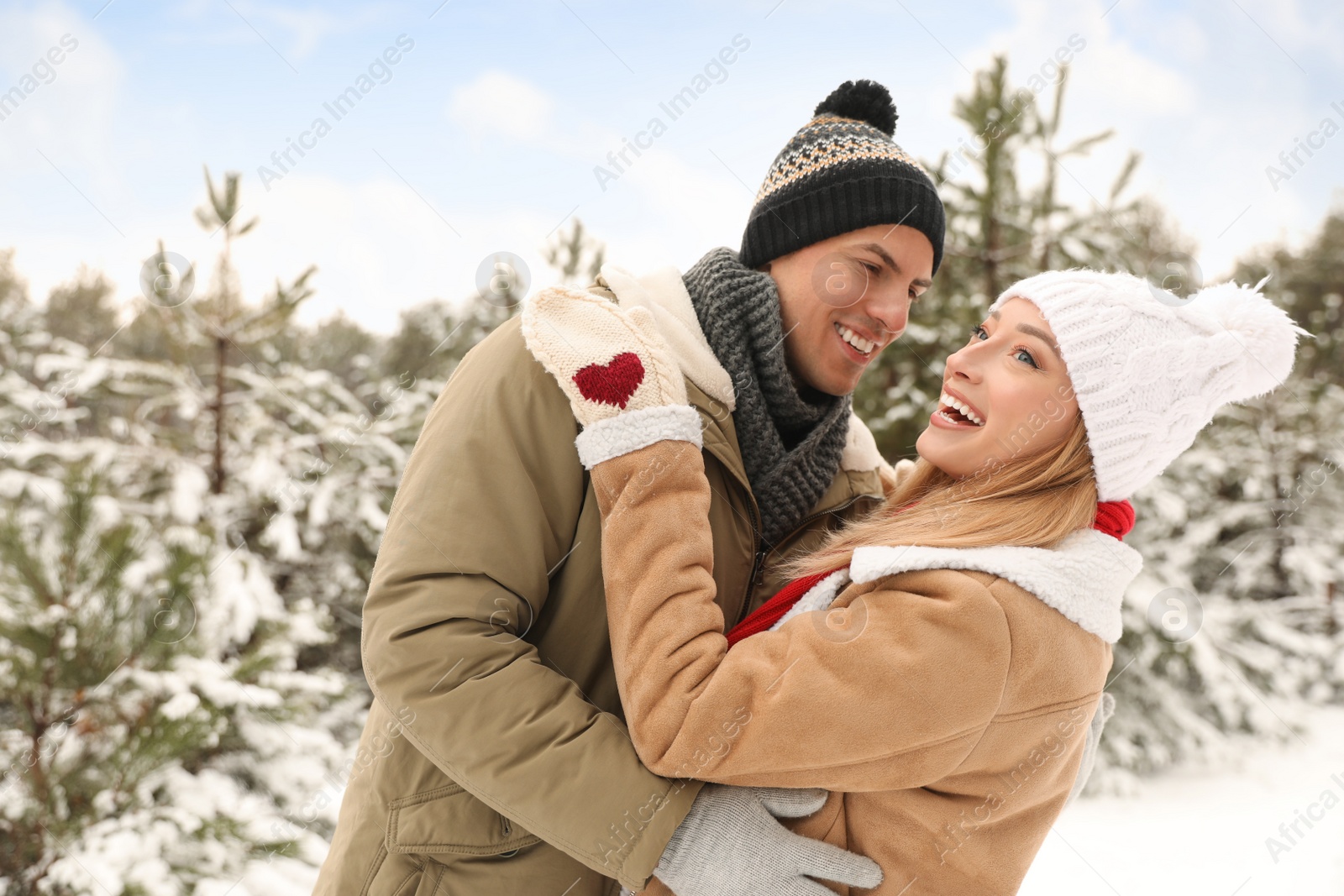 Photo of Beautiful happy couple in snowy forest on winter day