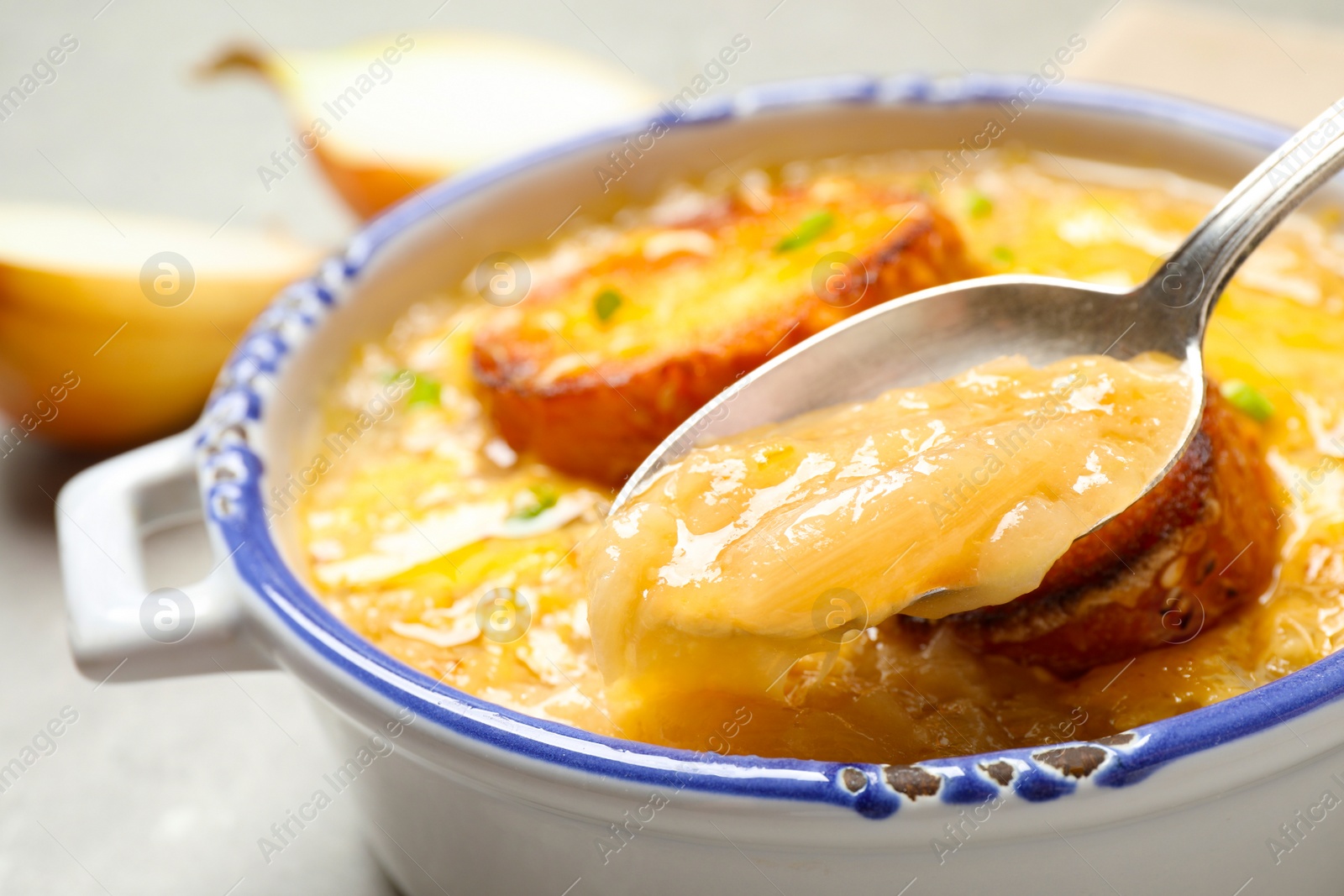 Photo of Tasty homemade french onion soup on table, closeup