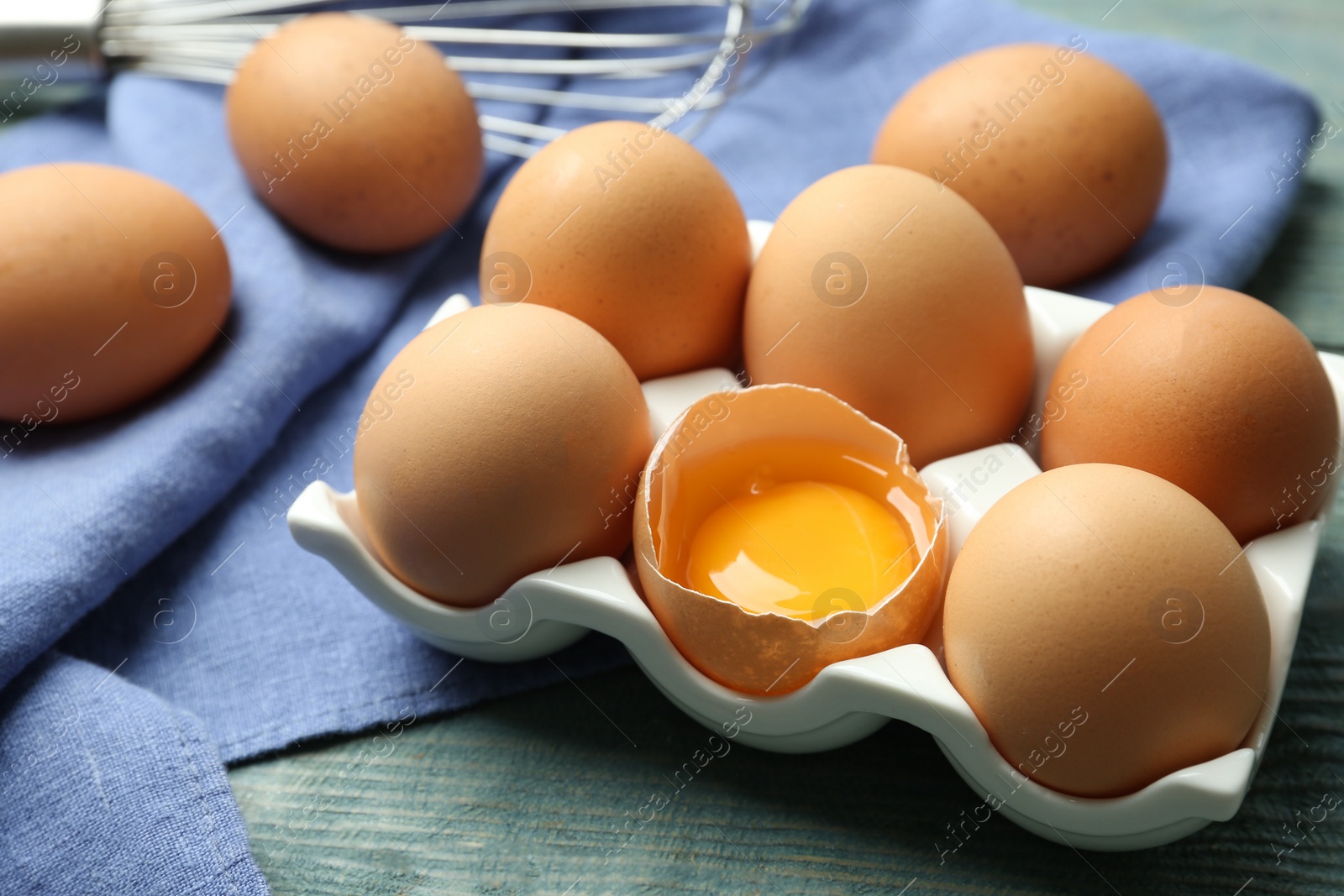 Photo of Raw chicken eggs on blue wooden table, closeup