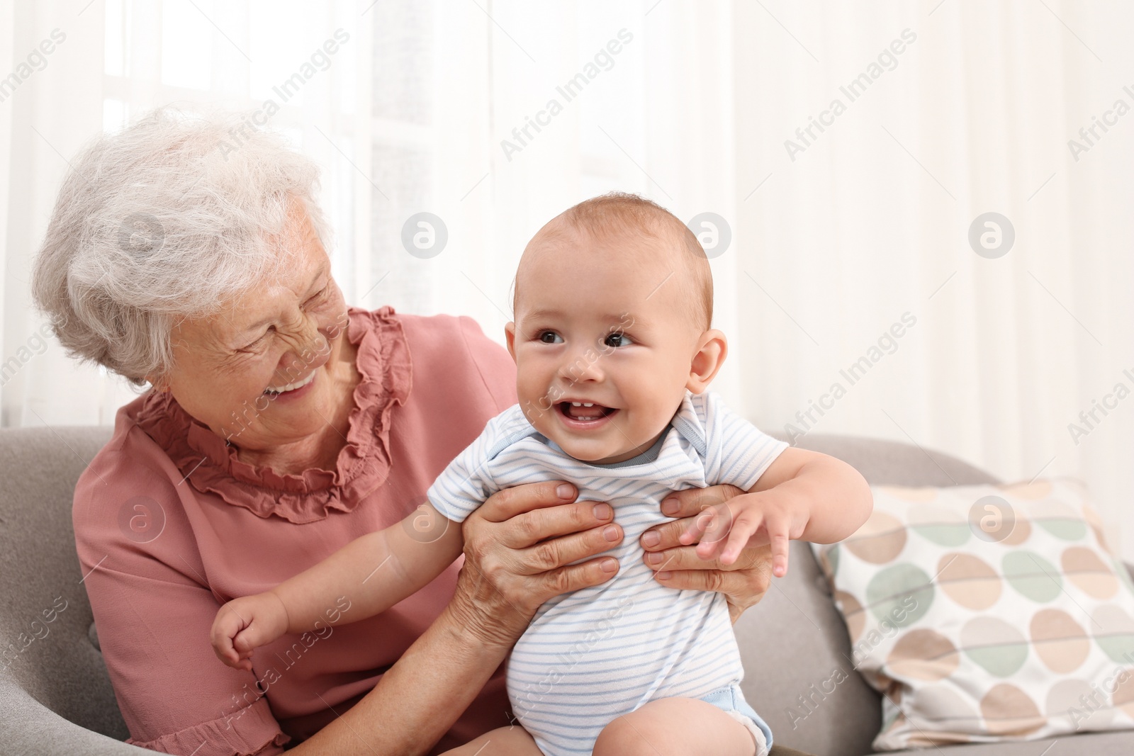 Photo of Happy grandmother with little baby at home