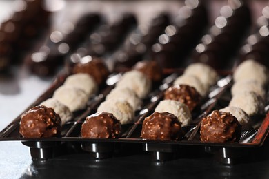 Photo of Many delicious chocolate candies on table. Production line