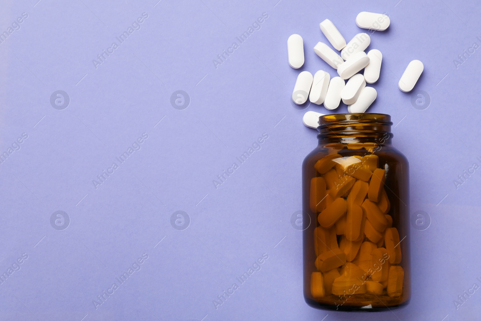 Photo of Bottle and vitamin capsules on violet background, top view. Space for text