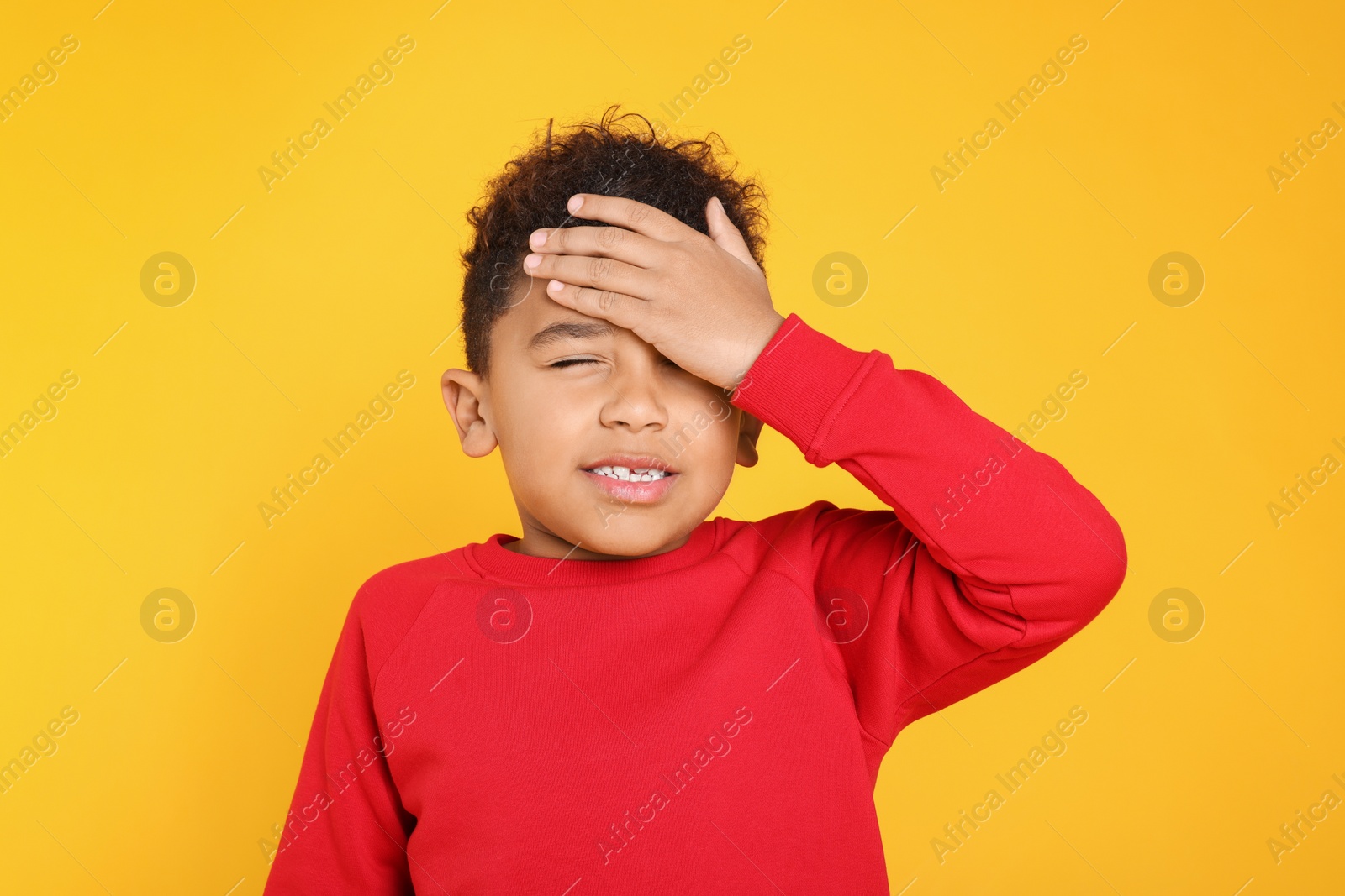 Photo of Portrait of emotional African-American boy on yellow background