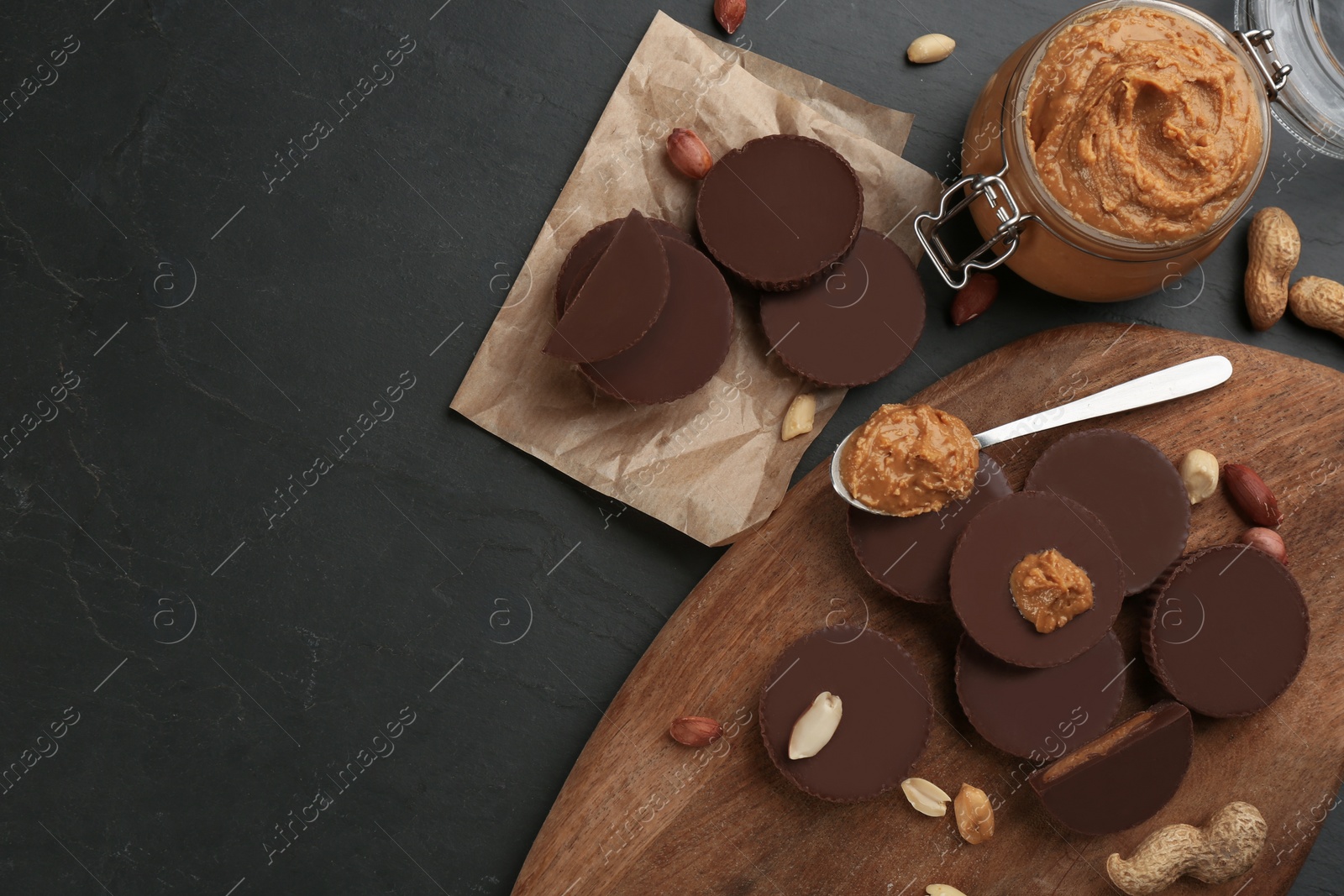 Photo of Flat lay composition with delicious peanut butter cups on black table, space for text