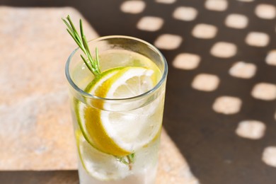 Photo of Summer refreshing lemonade on light brown table, closeup