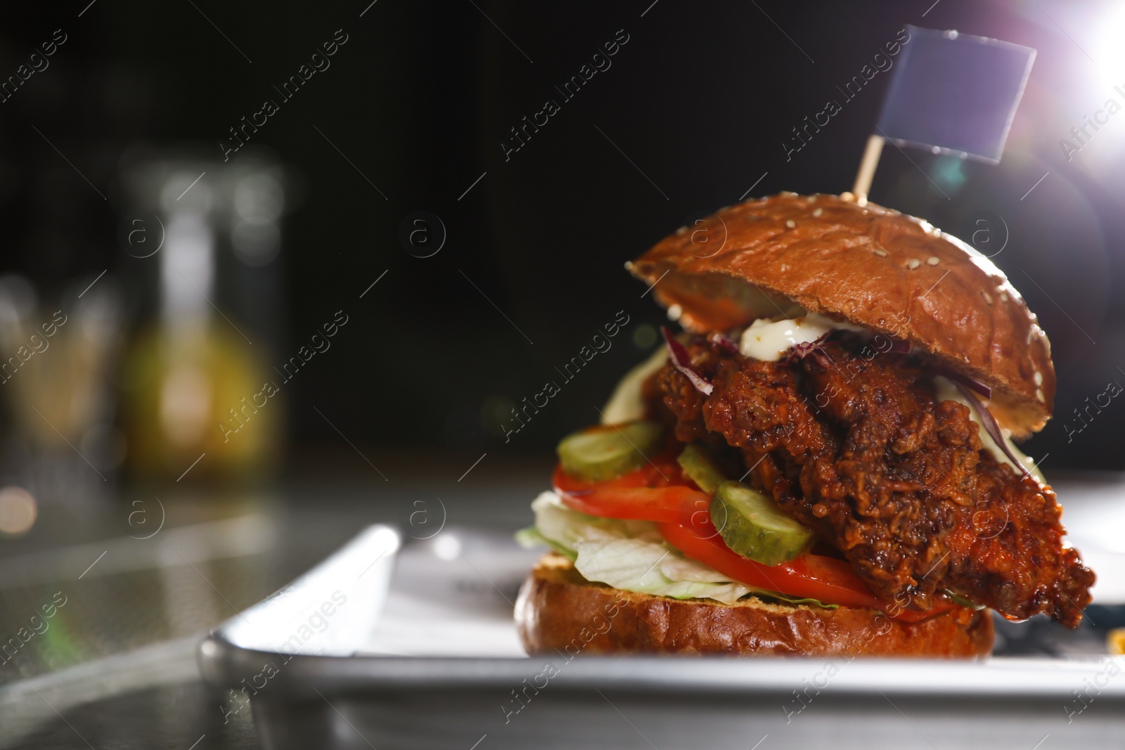 Photo of Tray with delicious burger on table against dark background. Space for text