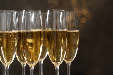 Photo of Glasses of champagne on blurred background, closeup. Space for text