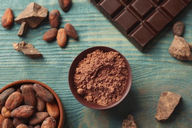 Photo of Flat lay composition with cocoa powder and chocolate bar on wooden background