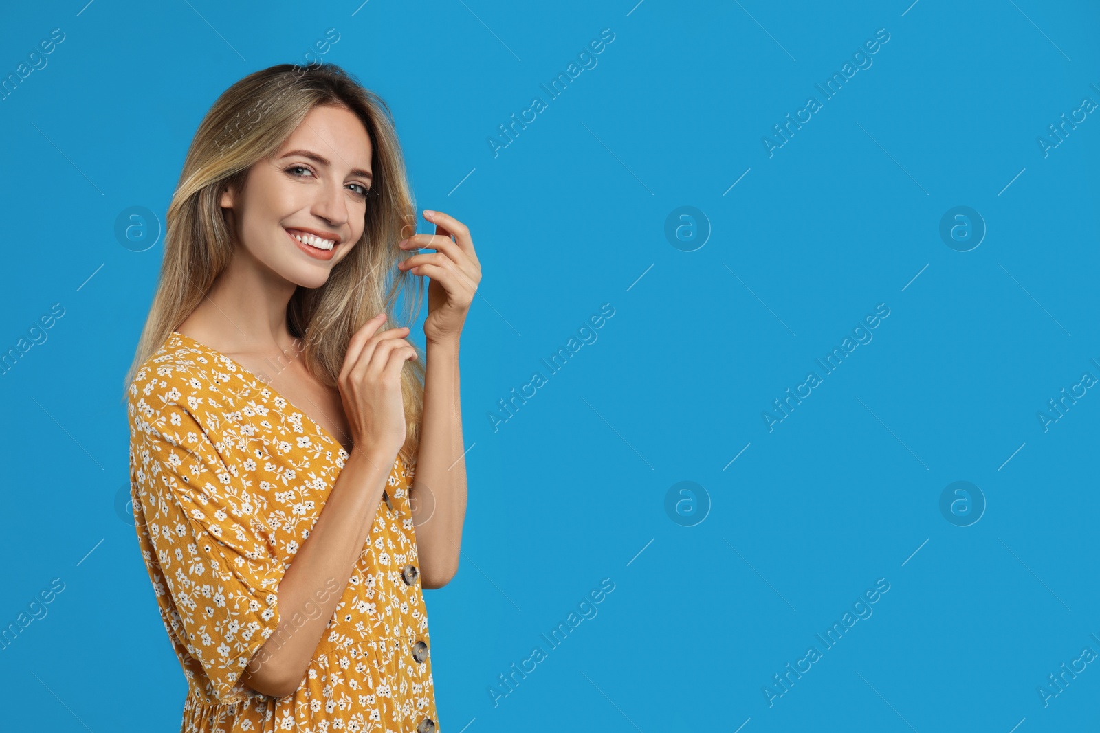 Photo of Young woman wearing stylish dress on blue background. Space for text