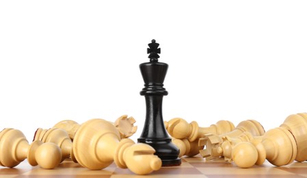 Photo of King among fallen chess pieces on wooden board against white background