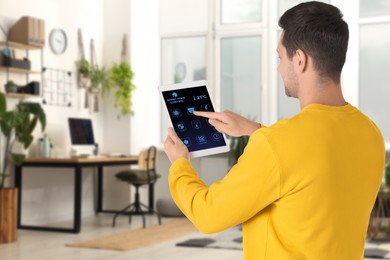 Image of Man using smart home control system via application on tablet indoors