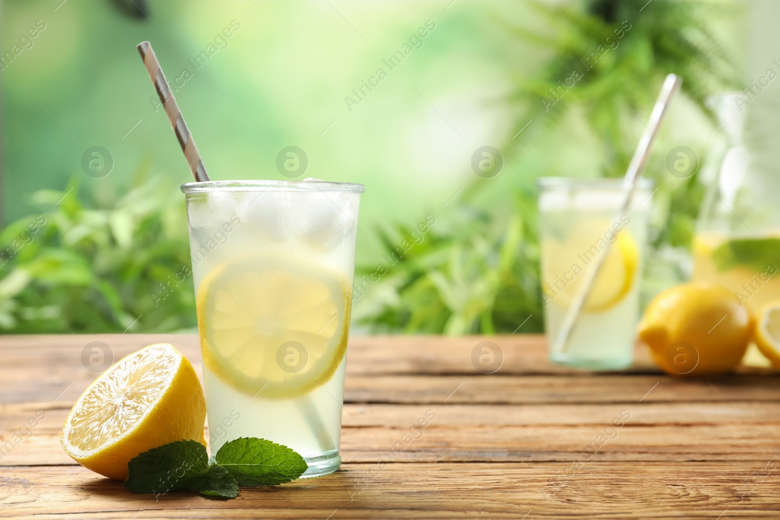 Photo of Natural lemonade with mint and fresh fruit on wooden table, space for text. Summer refreshing drink