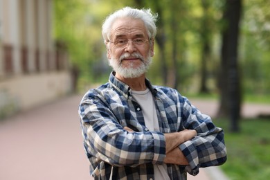 Portrait of happy grandpa with glasses in park