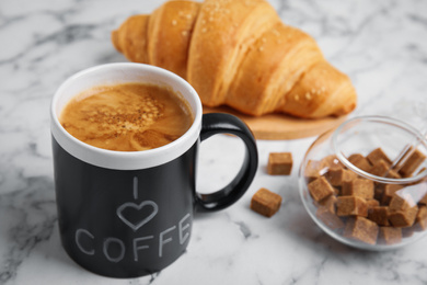 Photo of Delicious morning coffee, sugar and croissant on white marble table