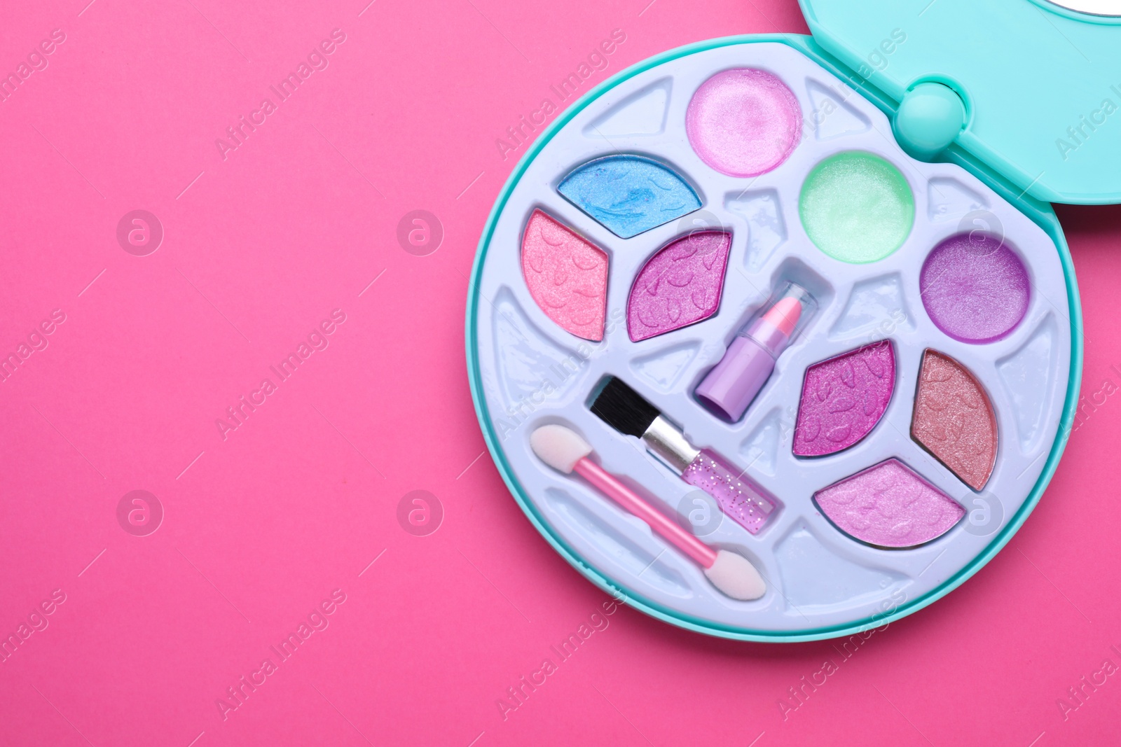 Photo of Decorative cosmetics for kids. Eye shadow palette with lipstick on pink background, top view. Space for text