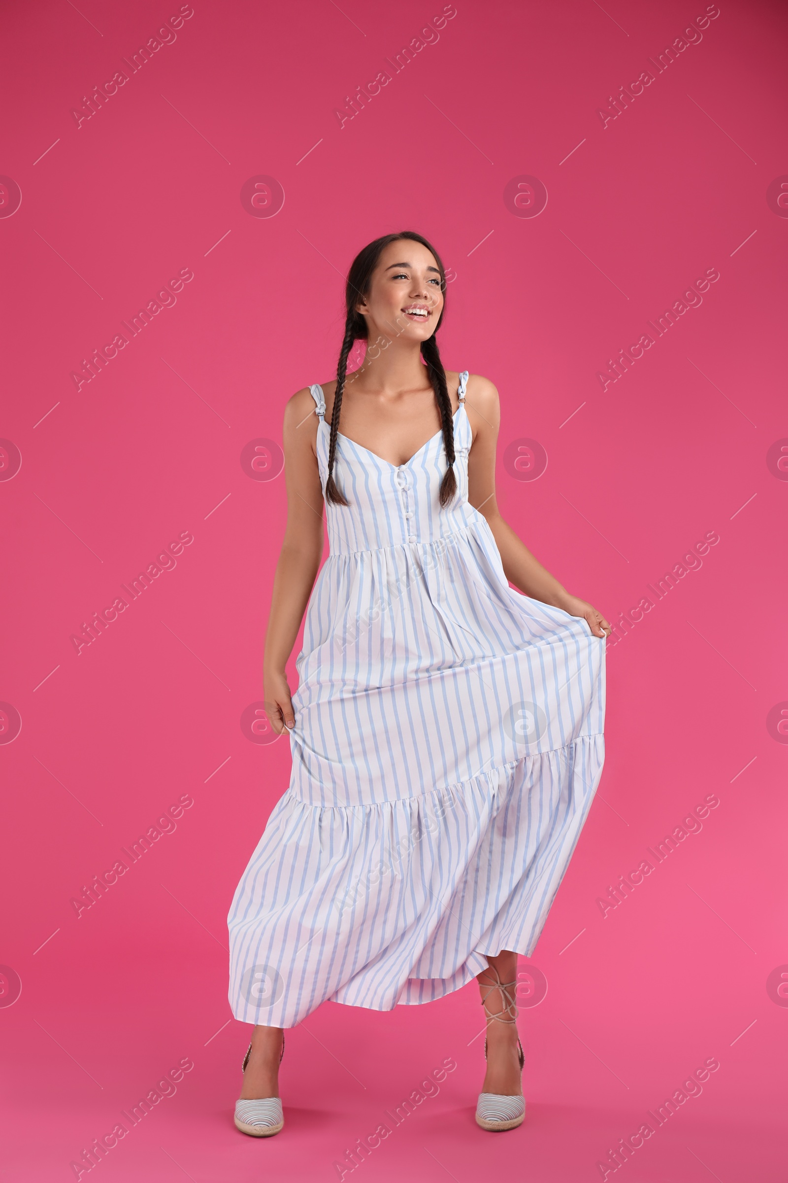 Photo of Young woman wearing stylish dress on pink background