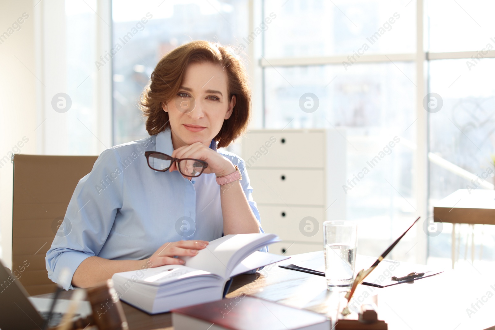 Photo of Female lawyer working at table in office