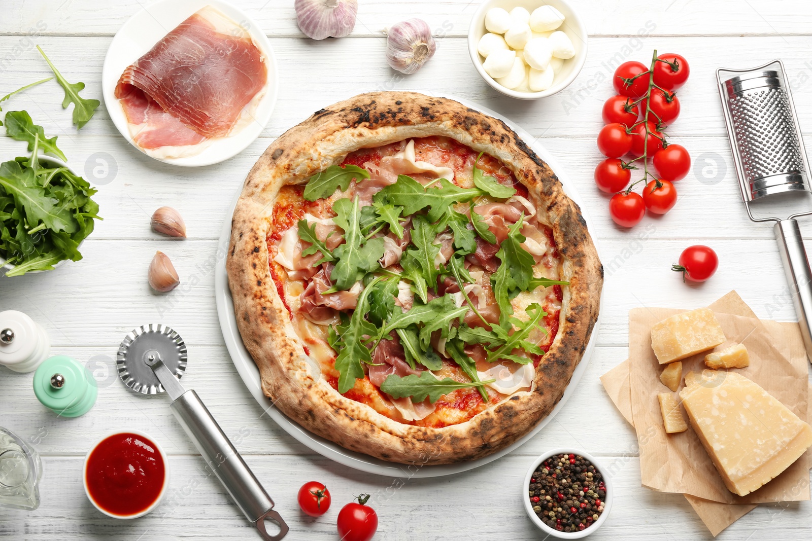 Photo of Tasty pizza with meat and arugula on white wooden table, flat lay