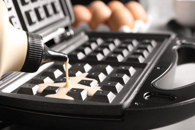 Photo of Pouring dough onto Belgian waffle maker, closeup