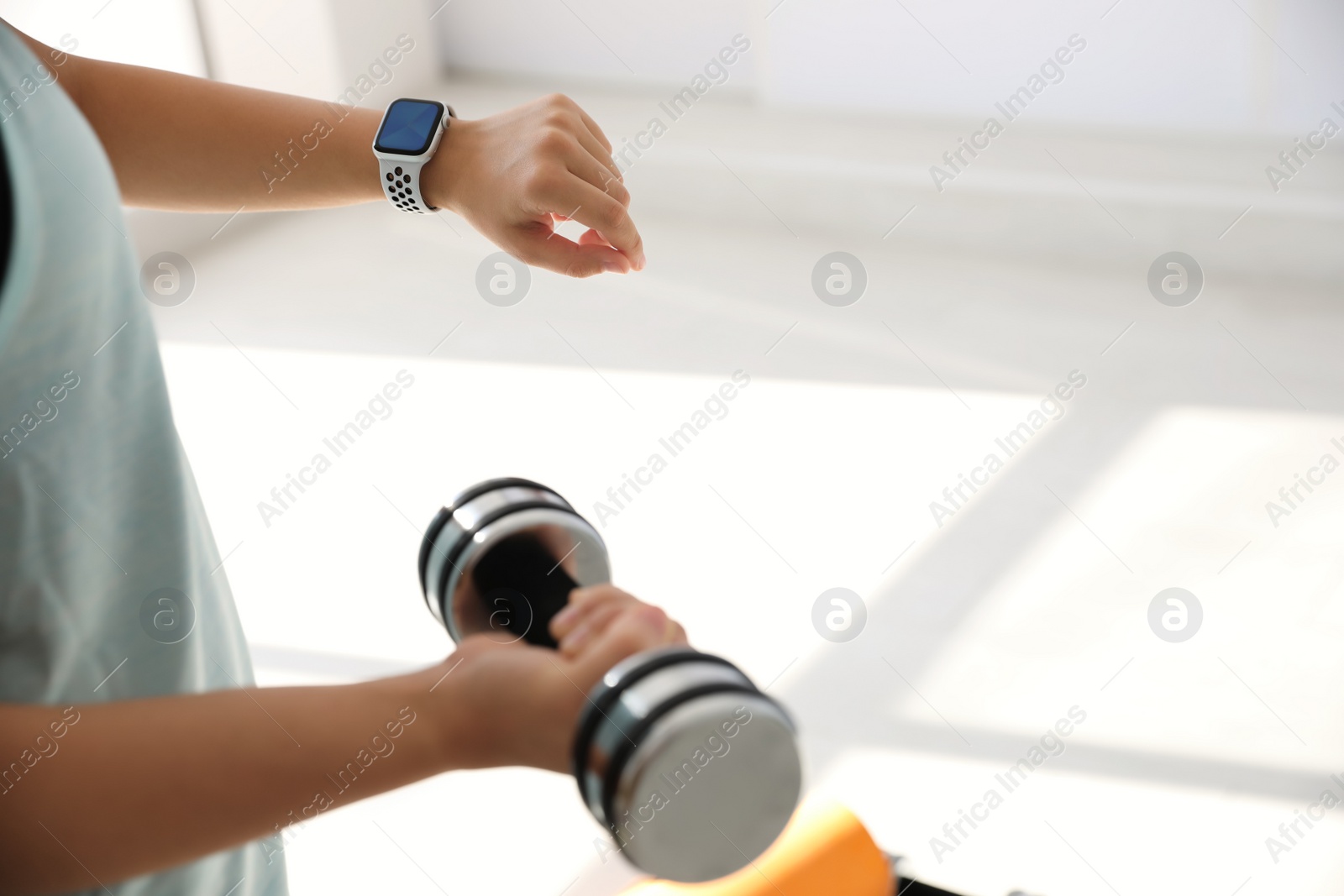 Photo of Woman checking fitness tracker in gym, closeup