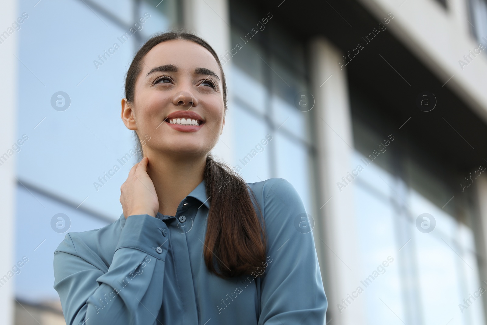 Photo of Portrait of beautiful woman outdoors, low angle view. Attractive lady smiling and posing for camera. Space for text