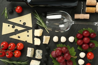Photo of Tasty red wine and snacks on black table, flat lay