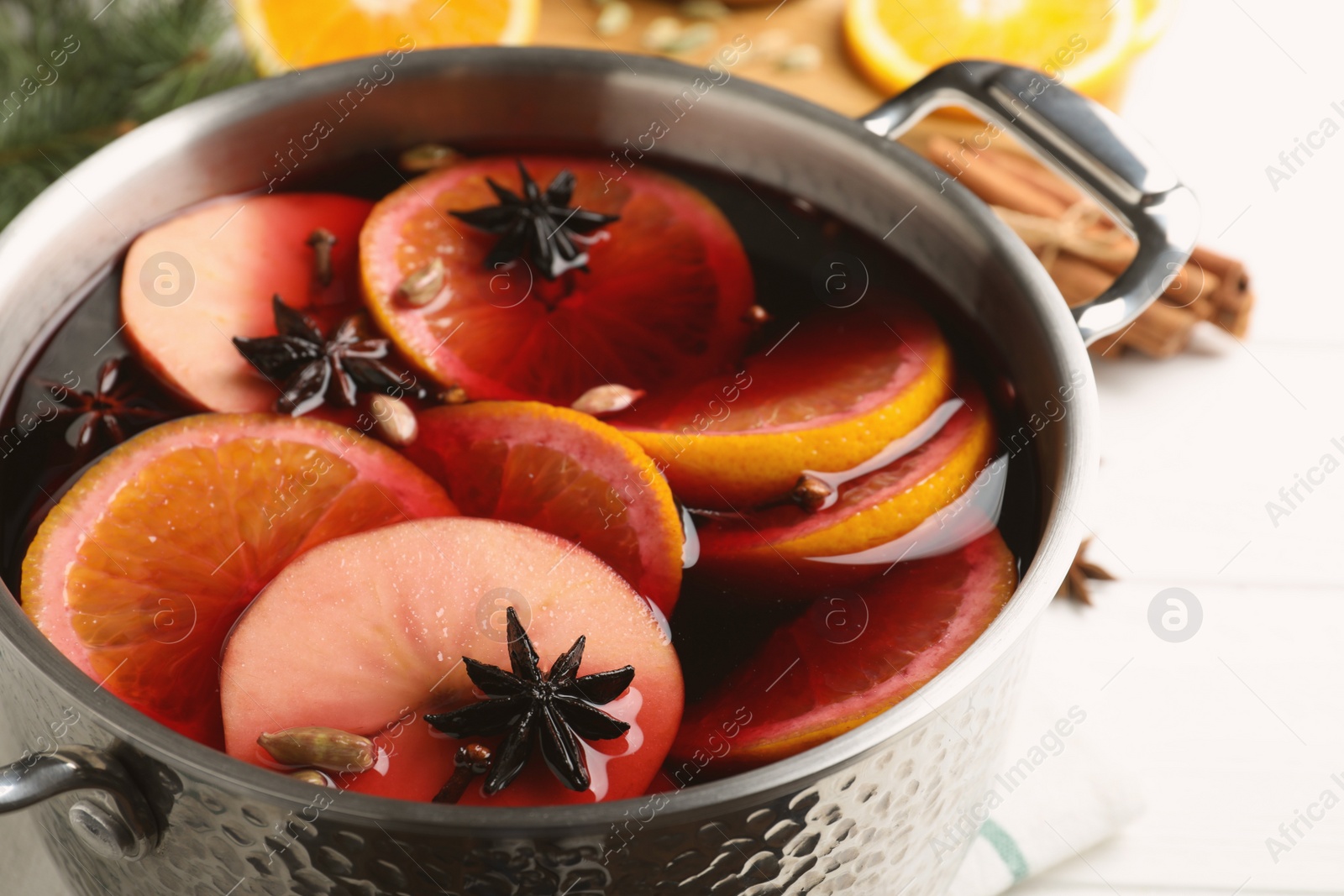 Photo of Delicious mulled wine on white table, closeup