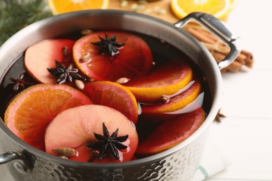 Photo of Delicious mulled wine on white table, closeup