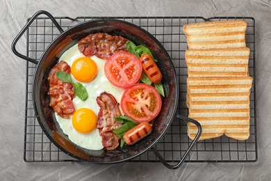 Photo of Delicious breakfast with fried eggs served on grey table, top view