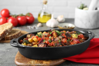 Dish with tasty ratatouille on grey textured table