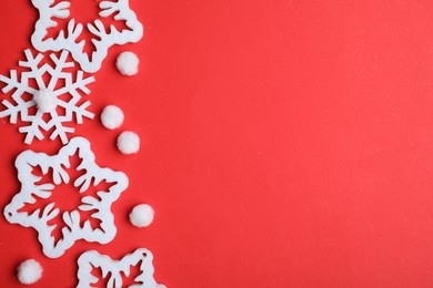 Photo of Beautiful decorative snowflakes on red background, flat lay. Space for text