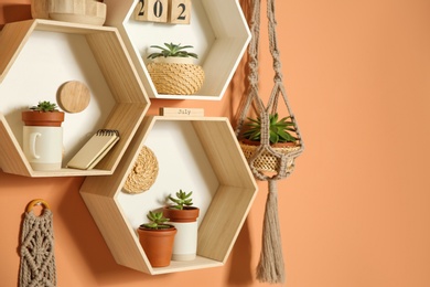 Shelves with decorative elements on color wall. Space for text