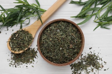 Bowl of dry tarragon, spoon and fresh leaves on white wooden table, flat lay