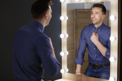 Photo of Young man looking at himself in mirror