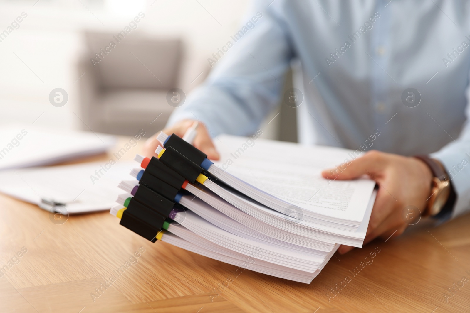 Photo of Businessman with documents at wooden table in office, closeup