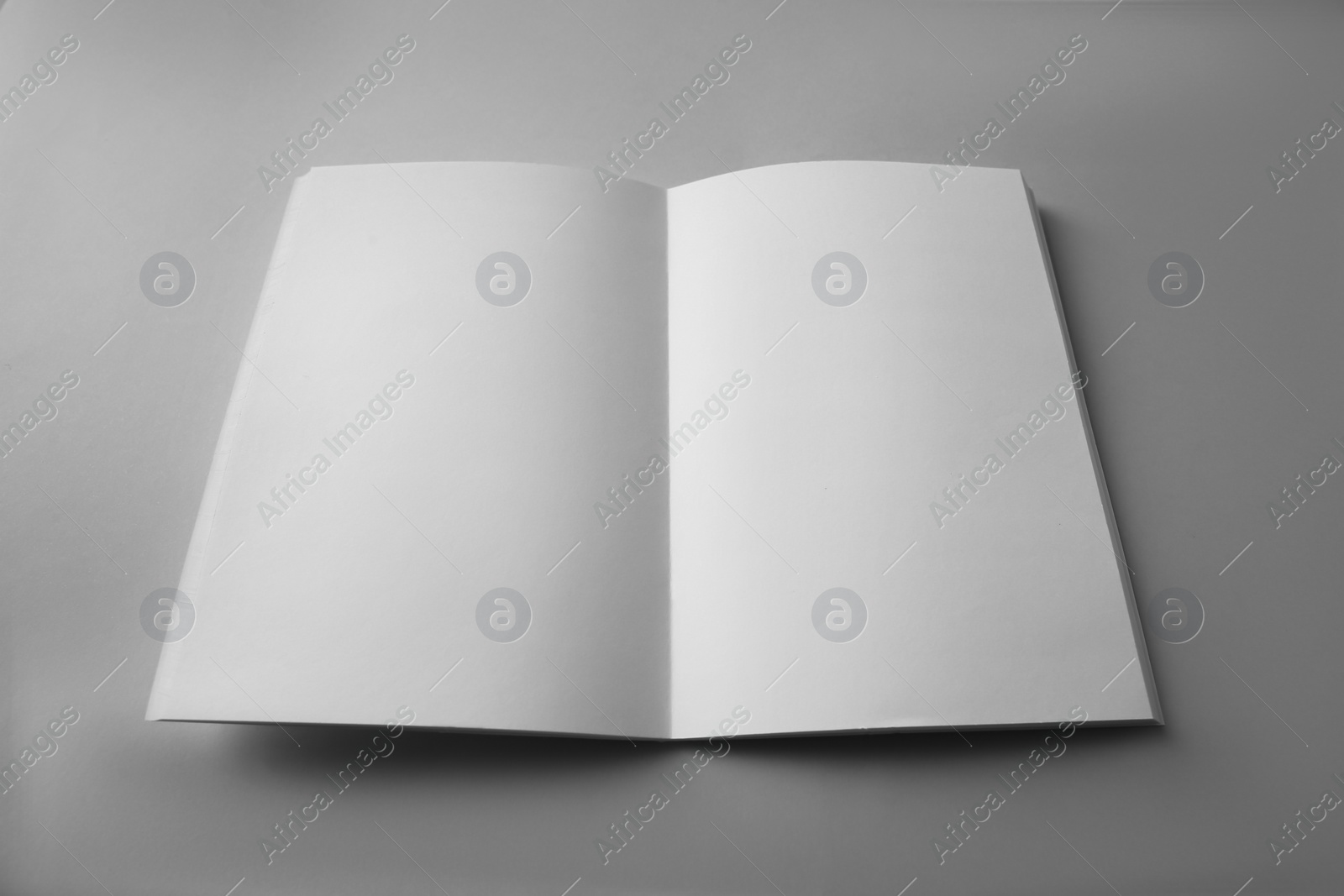 Photo of Open blank brochure on grey background. Mockup for design